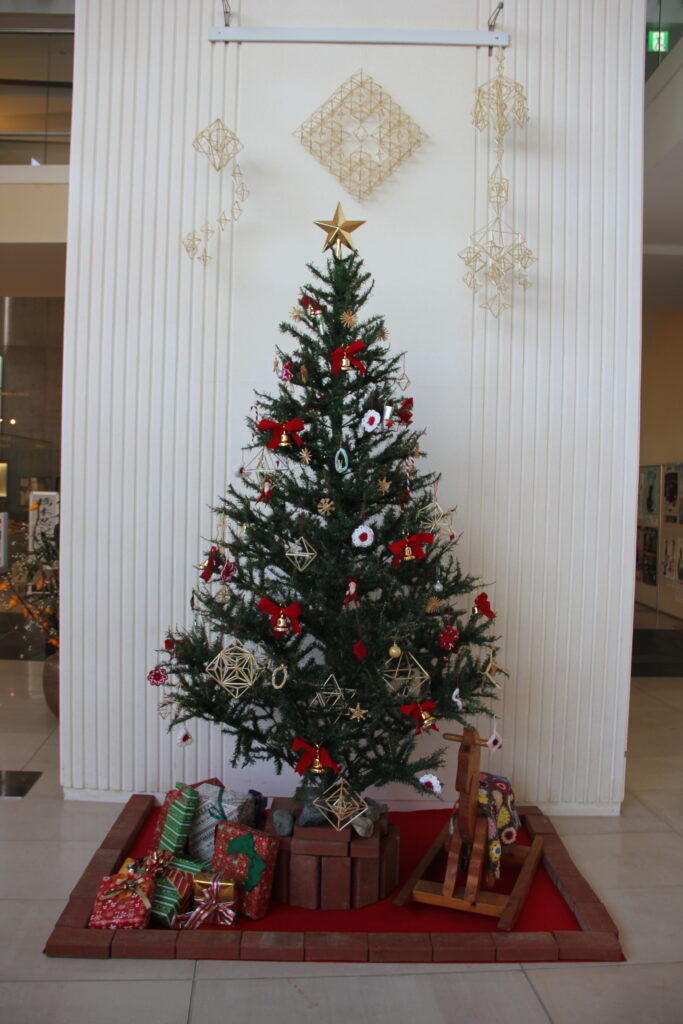 ２メートル近くある大きなクリスマスツリー。
赤いリボンのついた鈴の飾りと、麦わら細工のヒンメリが飾られている。
ツリーのてっぺんには星、足元にはたくさんのプレゼントと木馬のオブジェがある。